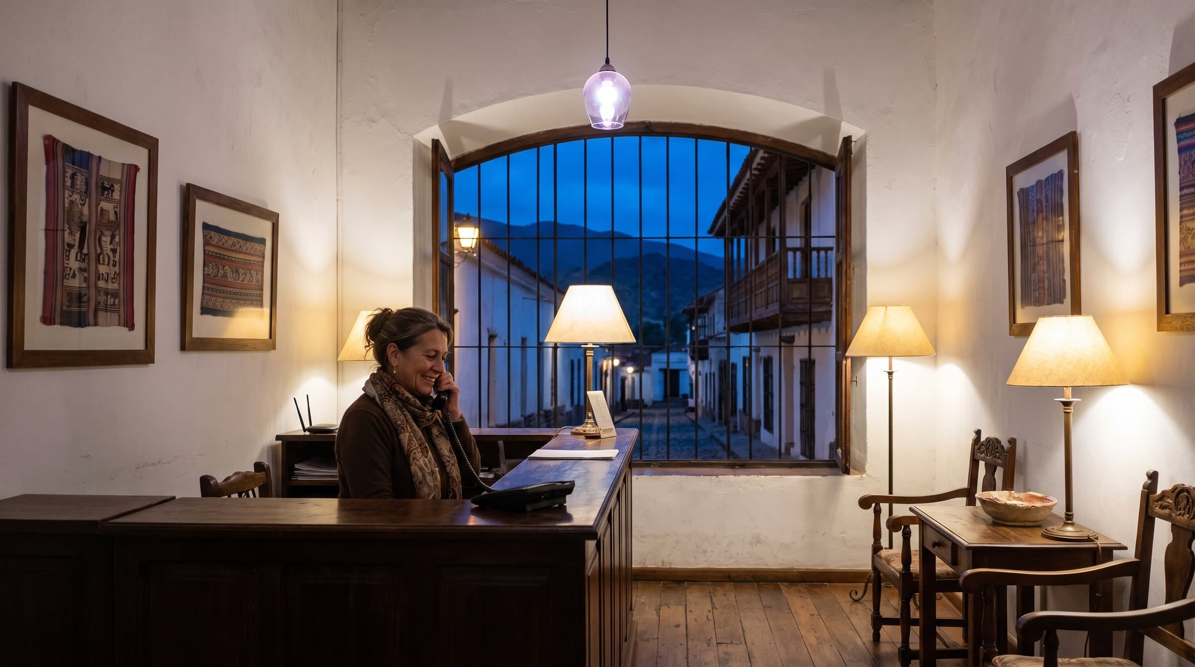 Recepcionista nocturno al teléfono en un hotel boutique colonial de Salta